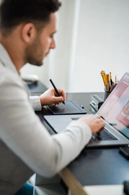 A sleek workspace with a laptop and monitors showing design software.
